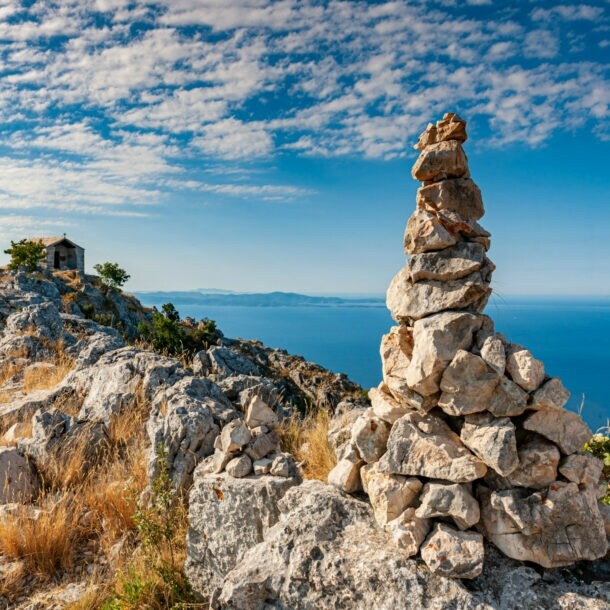 Blick von einem felsigen Berg aufs blaue Meer. 