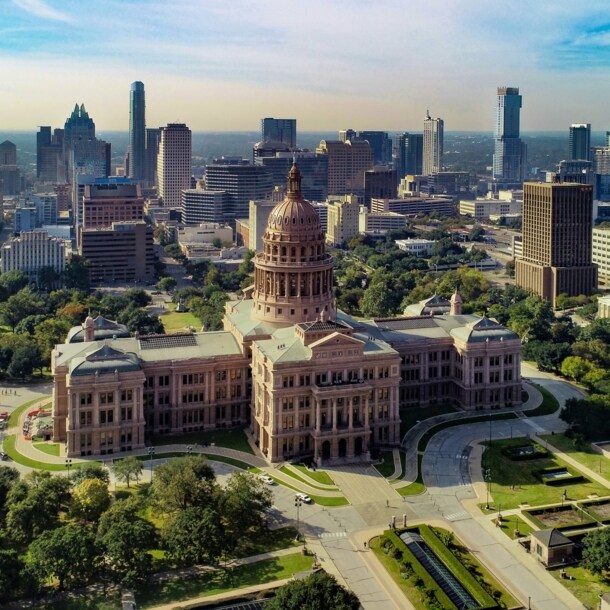 Texas State Kapitolgeböude vor der Skyline von Austin aus der Luftperspektive.