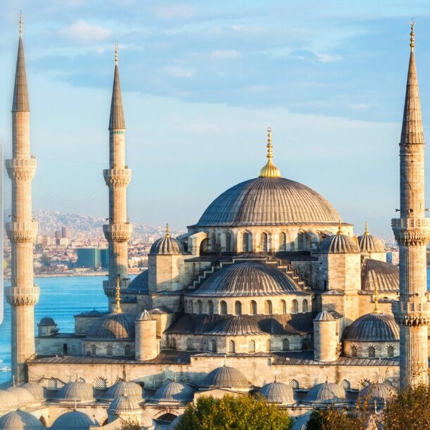 Große Moschee am Wasser vor dem Stadtpanorama von Istanbul unter blauem Himmel.