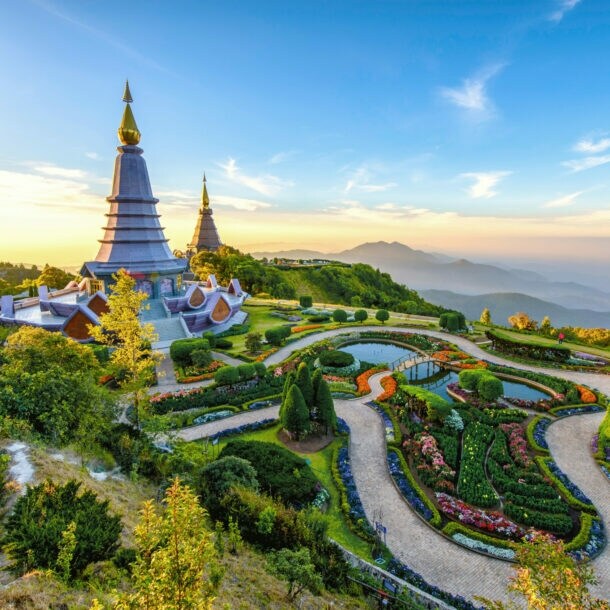 Buddhistische Tempelanlage mit spitzen Türmen und Landschaftsgarten auf einem Berg.