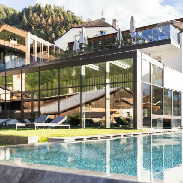 Blick auf das Hotel Weisses Kreuz mit Außenpool im Vordergrund.