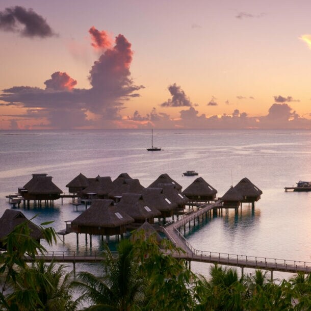 Blick auf die Anlage des Conrad Bora Bora Nui in der Dämmerung, mit seinen friedlich gelegenen Villen auf dem Wasser