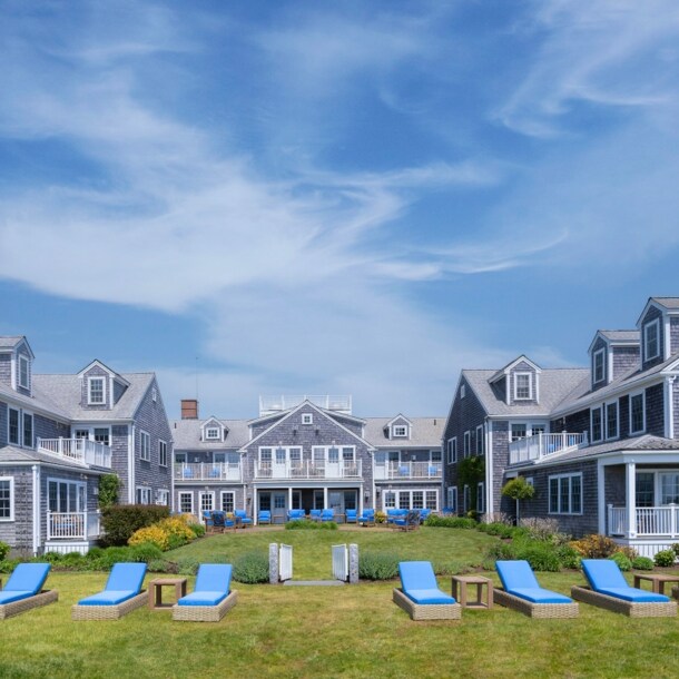 Blick auf die in U-Form stehenden Cottages des White Elephant, mit blau gepolsterten Liegen im Vordergrund.