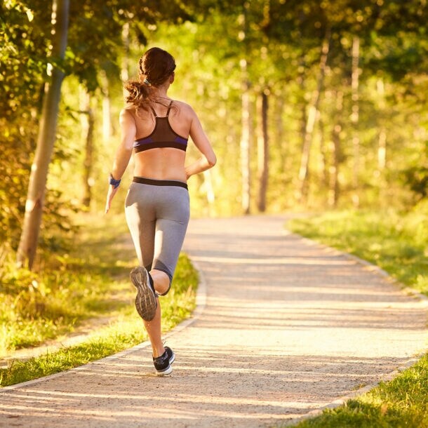 Eine Frau joggt am frühen Morgen im Park.