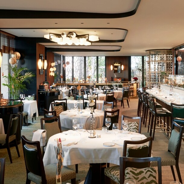 Edler Speisesaal mit eingedeckten Tischen und Barbereich in einem Luxusrestaurant.