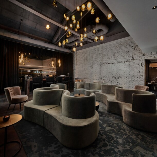 Gastraum in edlem Design, mit geschwungenen Polstermöbeln und einem Ambiente in Industriestil.