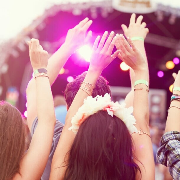 Jubelnde Personen von hinten vor eine Bühne.