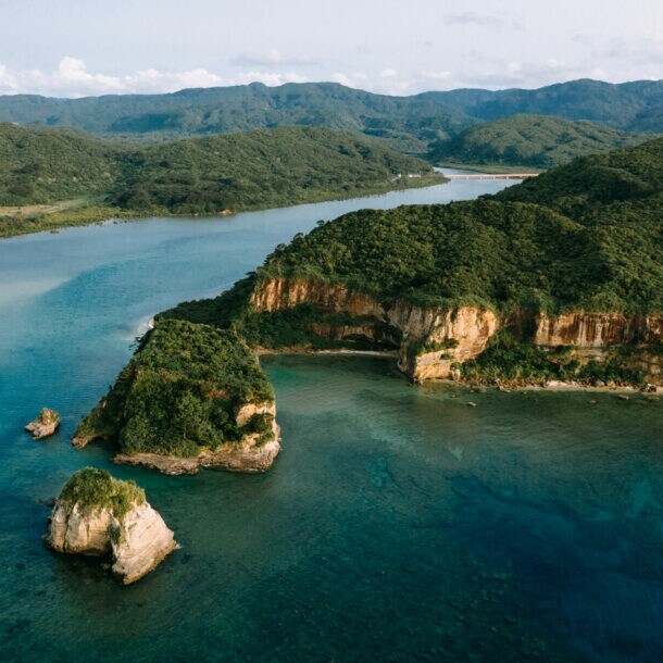 Luftaufnahme einer Inselgruppe mit bewaldeten Hügeln.