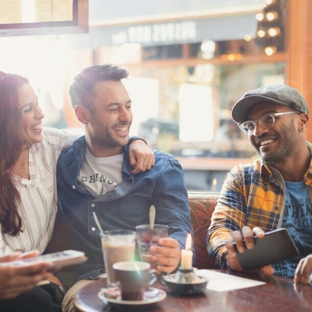 Gäste im Restaurant nutzen eine Buchhaltungsapp auf dem Smartphone.