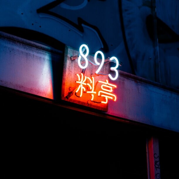 Close-up des schummrigen Neonschilds mit dem Restaurantnamen über dem unauffälligen Eingang des 893 Ryōtei.