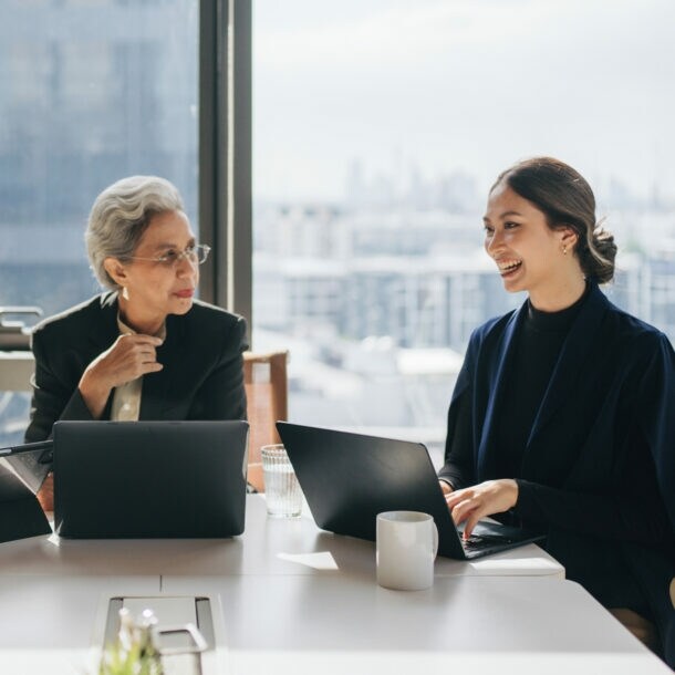Teamgeist: Eine Gruppe von Frauen verschiedener Altersgruppen tauscht sich in einem hellen Meetingraum aus.