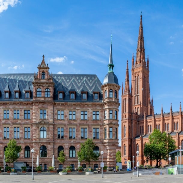 Blick auf das Neue Rathaus und die Marktkirche in Wiesbaden während eines leicht bewölkten Sommertags.