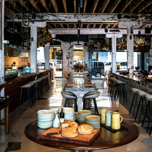 Modernes Restaurant im Industrie-Stil mit offener Küche und Bar.