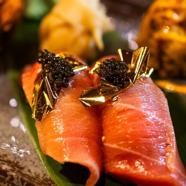 Nahaufnahme von edel angerichtetem Sashimi Sushi mit Blattgold und Kaviar.
