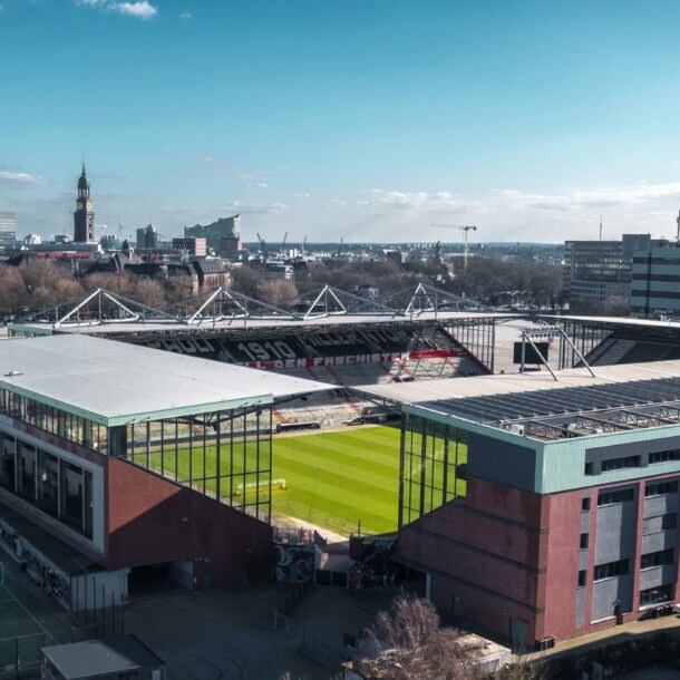 Rechteckiges Fußballstadion im Innenstadtbereich vor Hamburger Skyline am Horizont.