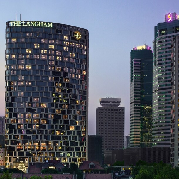 Beleuchtete Skyline mit Wolkenkratzern bei Abenddämmerung.