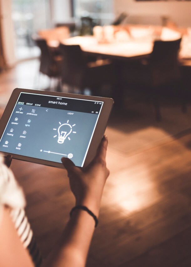 Frau hält Tablet in den Händen auf dem eine Glühbirne zu sehen ist