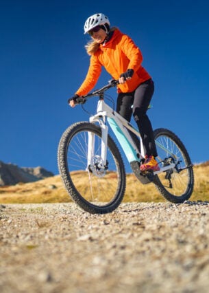Eine Frau fährt auf einem Mountainbike einen Berg herunter