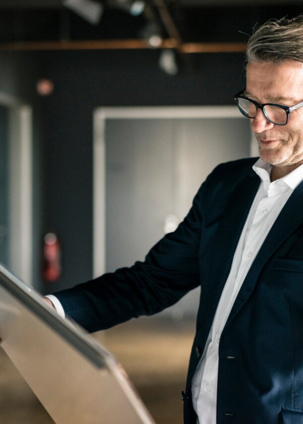 Ein Mann hält ein Kunstwerke hoch und schaut darauf