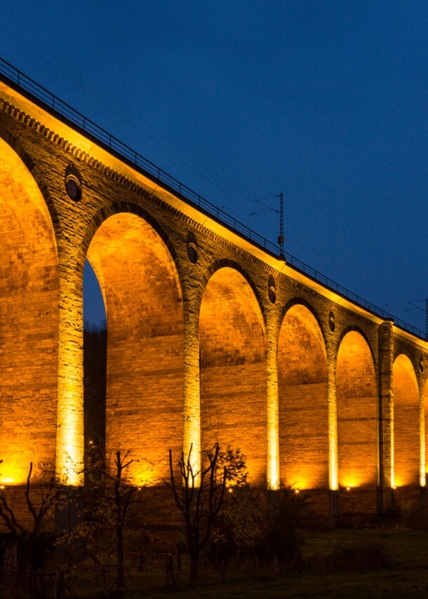 Hell beleuchtetes Viadukt bei Dunkelheit