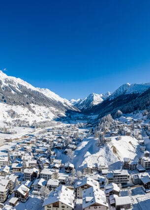 Blick auf die verschneite und im Tal liegende Ortschaft Klosters