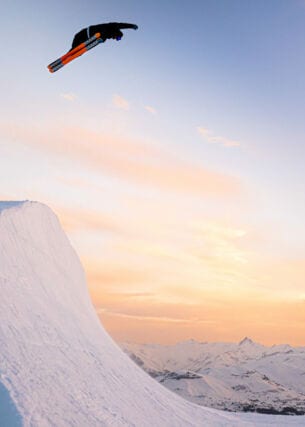 Eine Halfpipe bei Sonnenuntergang mit einem Snowboarder