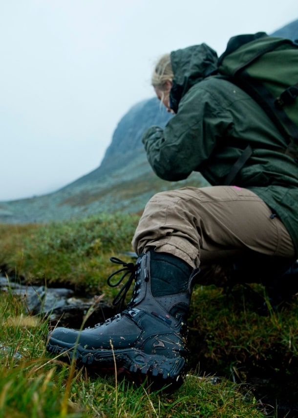 Frau mit Wanderschuhen in regnerischer Berglandschaft