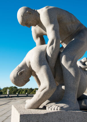Eine steinerne Skulptur, bei der ein Mann einen zusammengesunkenen Mann hält