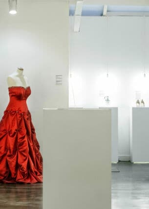 Ein rotes Abendkleid auf einer Schneiderpuppe in einem weißen Showroom