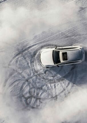 Ein Mercedes E-Auto fährt im Schnee.