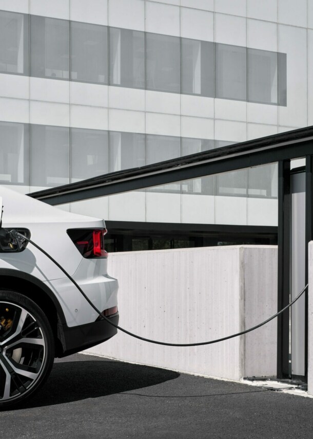 Ein weißes E-Auto an einer Ladestation.