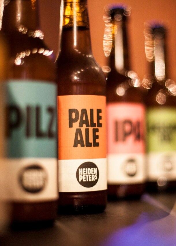 Bierflaschen mit bunten Etiketten aneinandergereiht