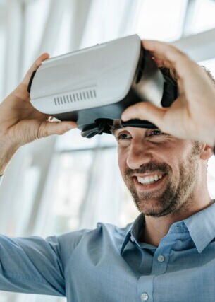 Ein junger Mann setzt eine VR-Brille ab.