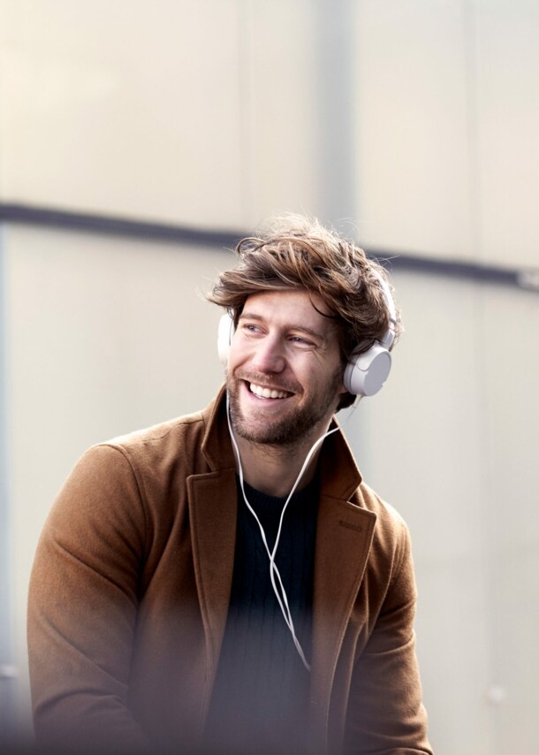 Frau in Jogginganzug steht vor einer Hauswand