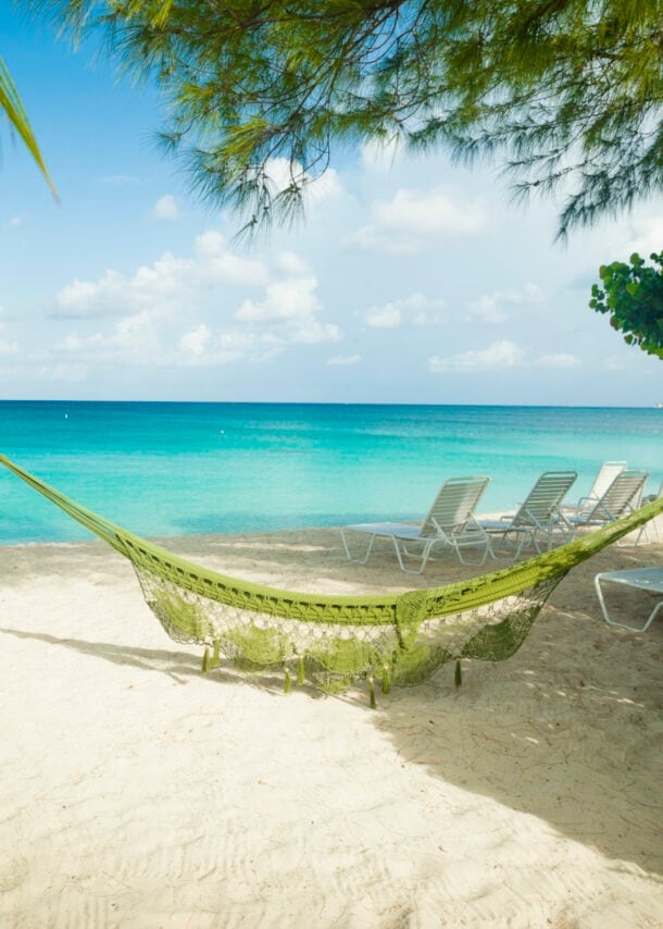 Eine Hängematte hängt am Sandstrand auf Jamaika