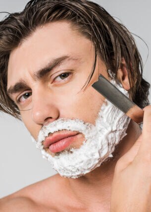 Ein Mann rasiert sich mit Rasiermesser