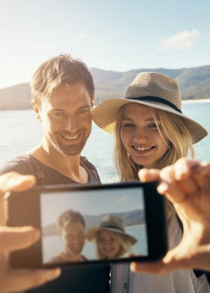 Frau und Mann machen ein Selfie am Strand