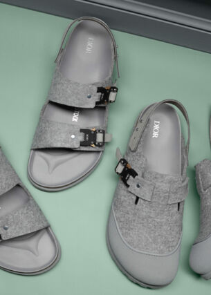 Detailaufnahme von zwei Paar grauer Sandalen mit Dior- und Birkenstock-Logo