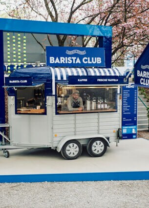Pferdewagen, der zur mobilen Kaffeestation umgebaut wurde, in dem ein Mann bedient