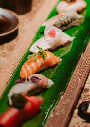 Sushi auf einer länglichen Platte angerichtet.