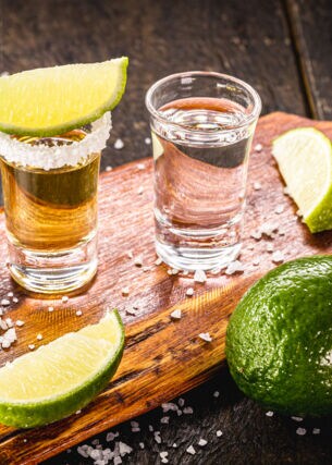 Zwei Gläser Tequila mit Limetten und Salz