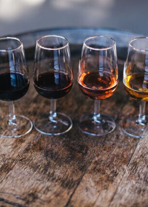Vier Gläser Portwein auf einem Fass