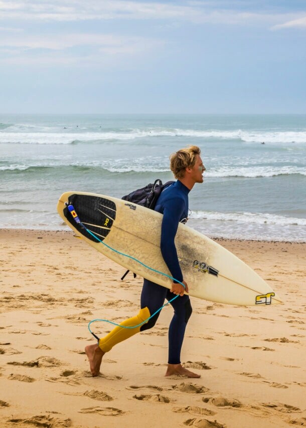 Ein Surfer mit Surfbrett an einem Strand