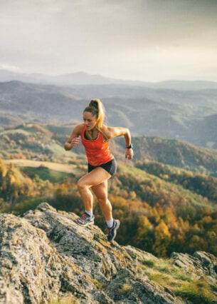 Eine laufende Frau auf einem Pfad im Gebirge