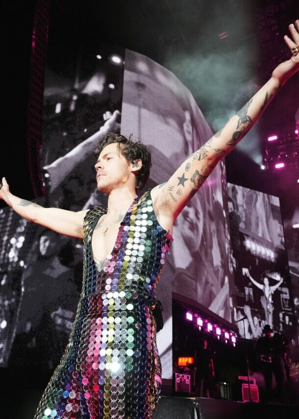 Sänger Harry Styles in einem glitzernden Paillettenanzug auf einer Bühne