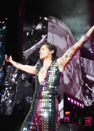 Sänger Harry Styles in einem glitzernden Paillettenanzug auf einer Bühne