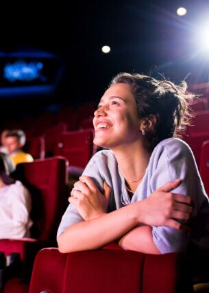 Eine junge Frau genießt einen Film im Kino