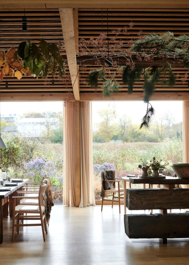Innenraum eines Restaurants mit Blick nach draußen auf eine Wiese voller Wildblumen