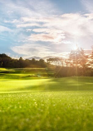 Ein Golfplatz mit wehender Fahne im Sonnenschein