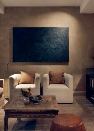 Luxuriöse Hotelsuite mit Designermöbeln in Natur- und Brauntönen und einem Fernseher.